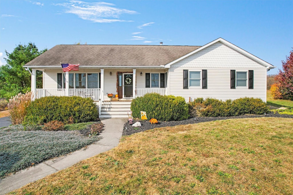 single story home with a porch and a front lawn