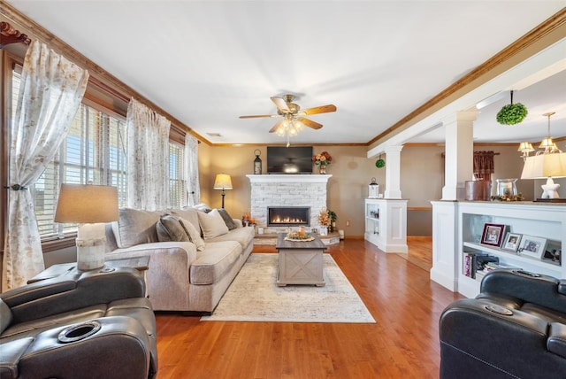 living room with ornamental molding, a healthy amount of sunlight, hardwood / wood-style floors, and ornate columns