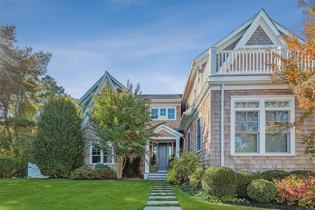 view of front of property with a balcony and a front yard