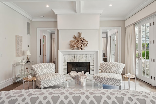 living area featuring a premium fireplace, crown molding, and wood-type flooring