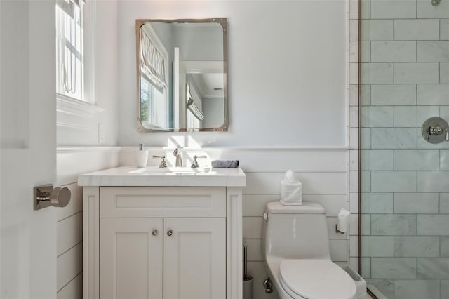 bathroom featuring tiled shower, vanity, and toilet