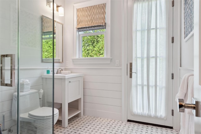 bathroom with a shower with door, vanity, and toilet