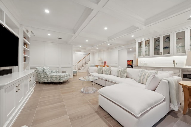 living room featuring beam ceiling, built in shelves, sink, coffered ceiling, and light tile patterned flooring