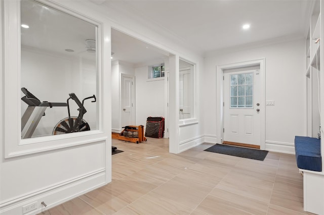 foyer featuring light tile patterned flooring and ornamental molding