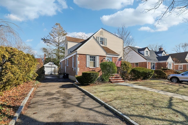 view of front of house with a garage, an outbuilding, and a front lawn