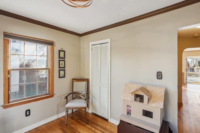 living area with hardwood / wood-style flooring and ornamental molding