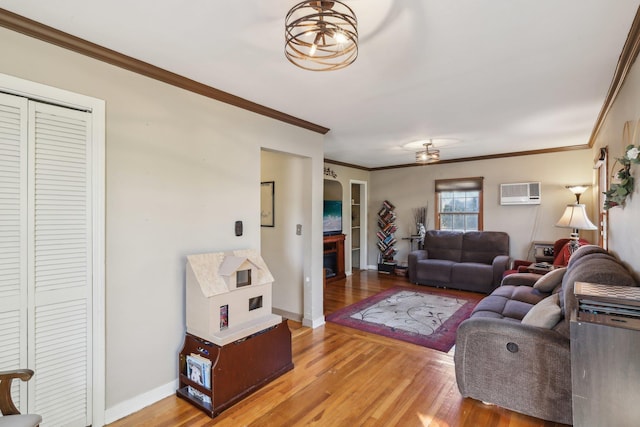 living room with crown molding, a wall mounted air conditioner, and hardwood / wood-style floors