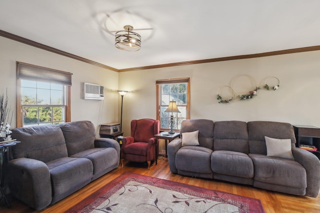 living room featuring ornamental molding, wood-type flooring, a wall unit AC, and a healthy amount of sunlight