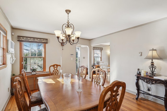 dining room with ornamental molding, an inviting chandelier, and light hardwood / wood-style flooring