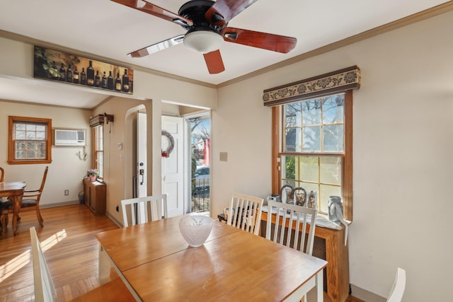 dining room featuring crown molding, ceiling fan, a wall mounted AC, and light wood-type flooring