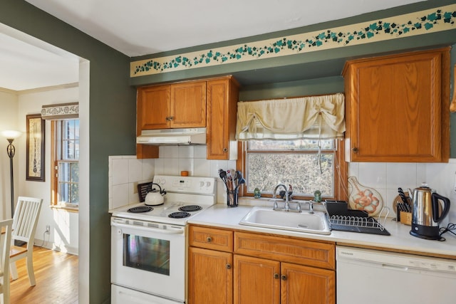 kitchen featuring tasteful backsplash, white appliances, a healthy amount of sunlight, and sink