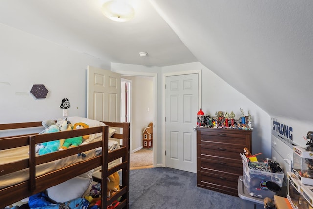 bedroom featuring lofted ceiling and dark colored carpet