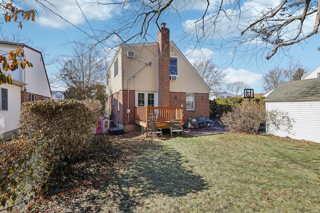 rear view of property featuring a wooden deck and a lawn