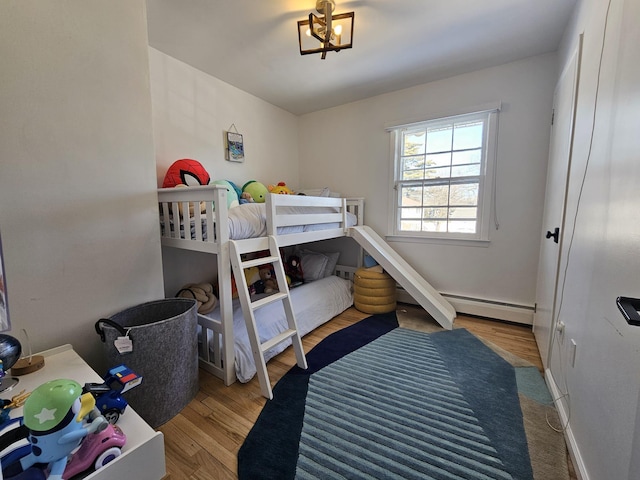 bedroom with a baseboard radiator and light wood-type flooring