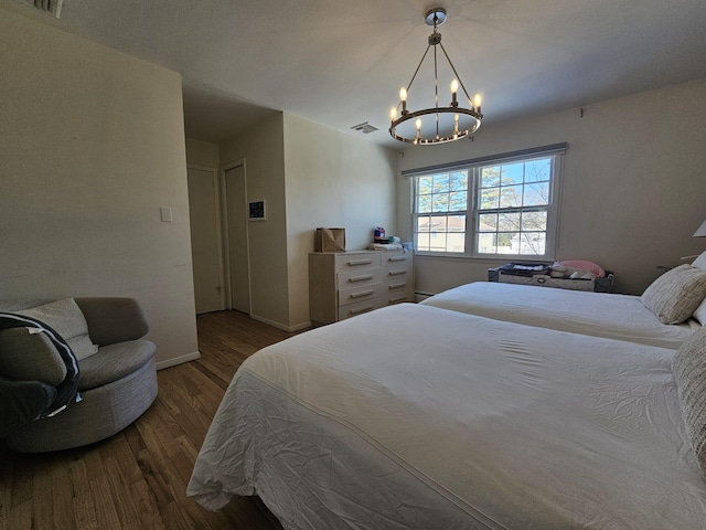 bedroom with an inviting chandelier and dark hardwood / wood-style flooring