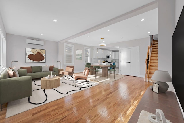 living room with light wood-type flooring, a wealth of natural light, and a wall mounted AC