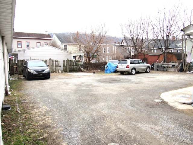 view of car parking with fence and a residential view