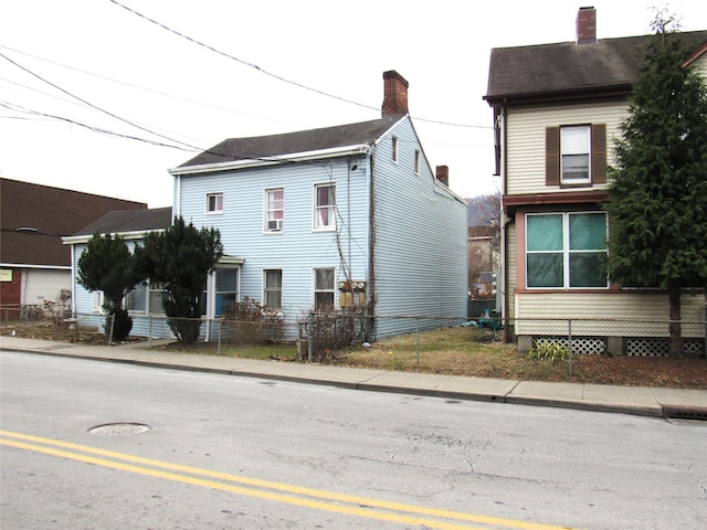 view of property exterior with fence and a chimney