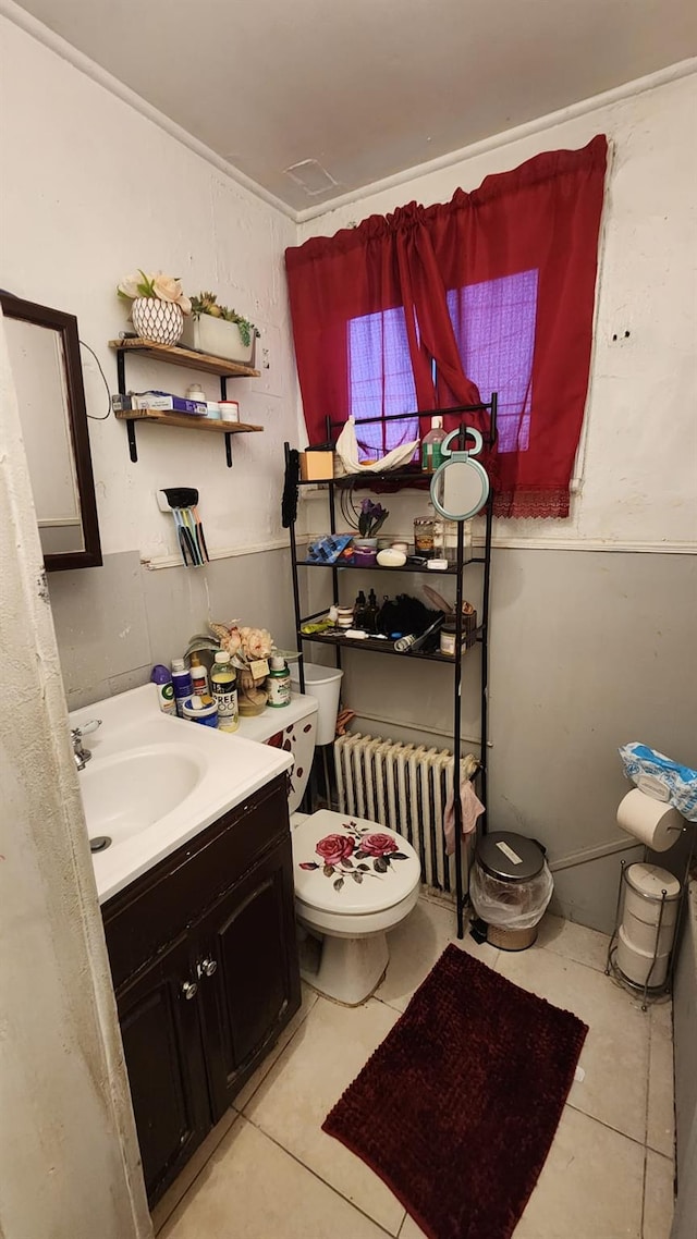 bathroom with toilet, radiator heating unit, vanity, and tile patterned floors