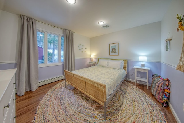 bedroom featuring light hardwood / wood-style floors and baseboard heating