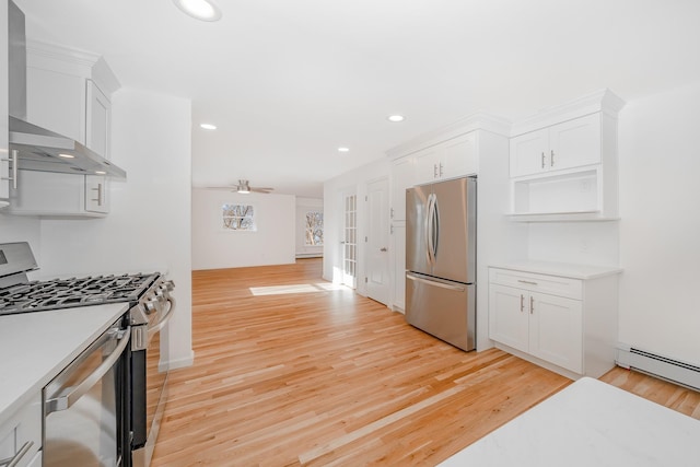 kitchen featuring stainless steel appliances, white cabinets, ceiling fan, and light hardwood / wood-style floors