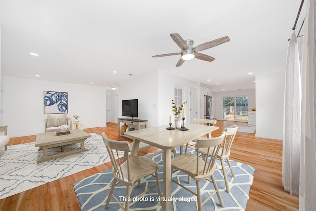 dining space featuring light wood-type flooring and ceiling fan