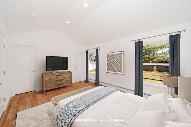 bedroom featuring multiple windows, lofted ceiling, and hardwood / wood-style flooring