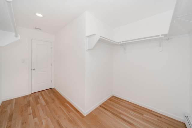 spacious closet featuring baseboard heating and light wood-type flooring