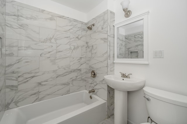 full bathroom featuring toilet, tiled shower / bath, and sink