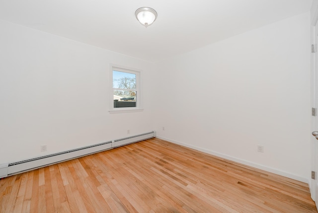 spare room featuring a baseboard radiator and wood-type flooring