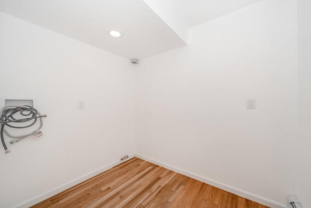 unfurnished room with baseboard heating and hardwood / wood-style flooring