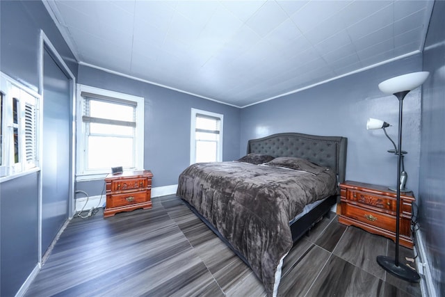 bedroom with ornamental molding and dark wood-type flooring