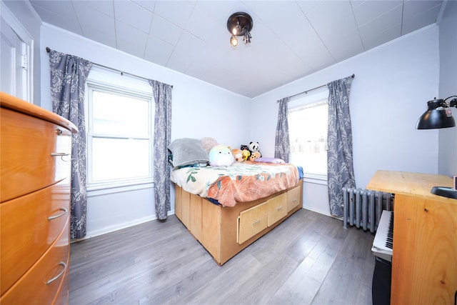 bedroom featuring hardwood / wood-style floors and radiator heating unit