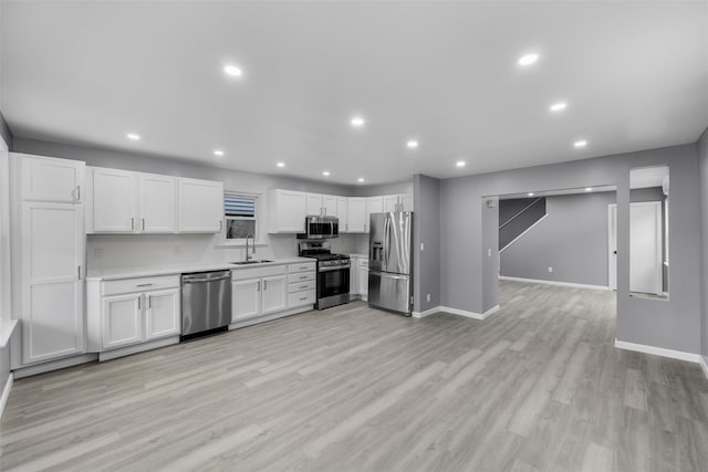 kitchen with light hardwood / wood-style flooring, stainless steel appliances, white cabinets, and sink