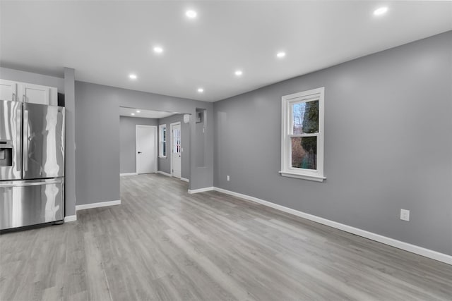 kitchen with light hardwood / wood-style flooring, stainless steel fridge, and white cabinetry