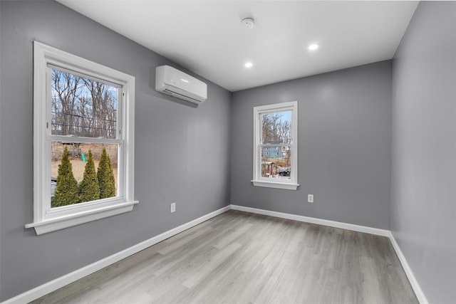 empty room featuring light hardwood / wood-style flooring and a wall unit AC