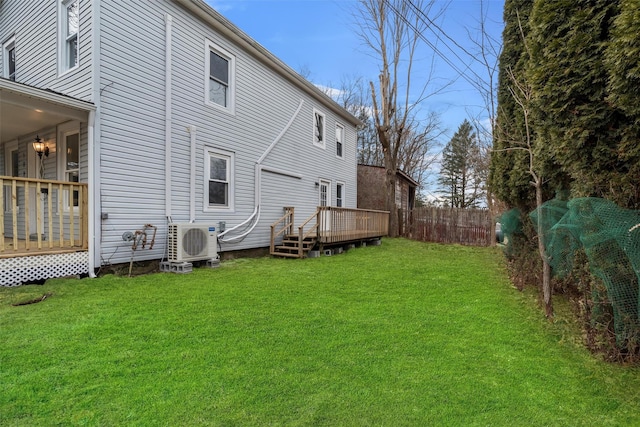 rear view of property featuring ac unit, a lawn, and a wooden deck