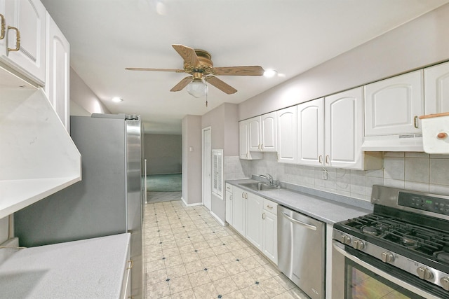 kitchen with ceiling fan, sink, backsplash, white cabinets, and appliances with stainless steel finishes