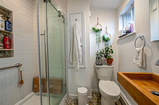 bathroom featuring toilet and a shower with door