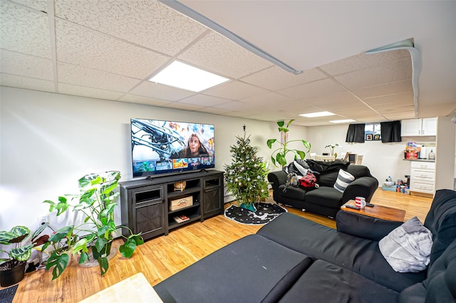 living room with wood-type flooring, a baseboard heating unit, and a paneled ceiling