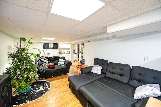 living room with a paneled ceiling and wood-type flooring