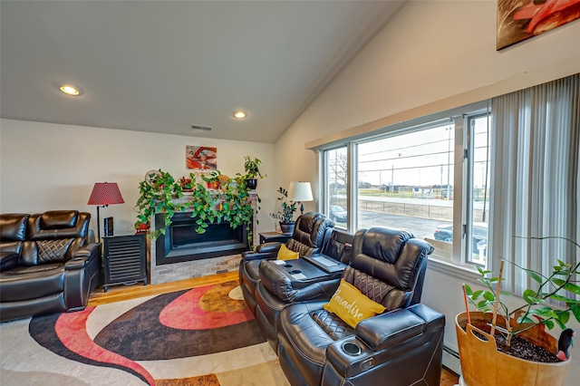 living room with a baseboard heating unit, a wealth of natural light, vaulted ceiling, and hardwood / wood-style floors