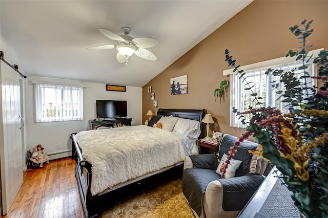 bedroom featuring a barn door, hardwood / wood-style floors, ceiling fan, baseboard heating, and lofted ceiling