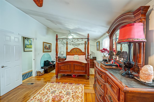 bedroom with light hardwood / wood-style floors, lofted ceiling, and ceiling fan