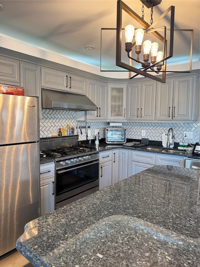 kitchen featuring a notable chandelier, stainless steel appliances, decorative light fixtures, and decorative backsplash