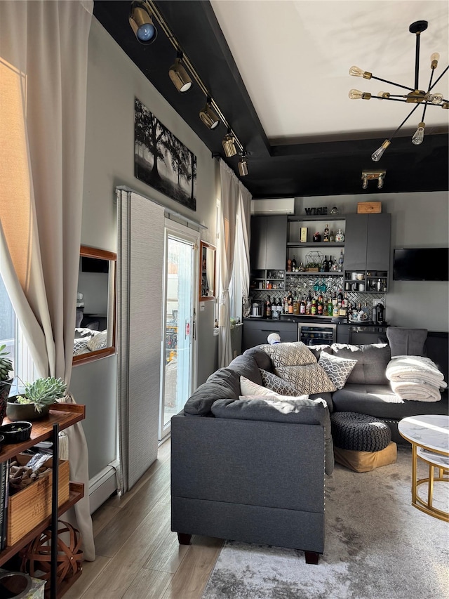 living room with bar area, light wood-type flooring, beverage cooler, and a wealth of natural light