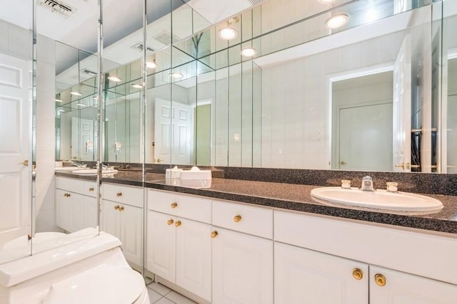 bathroom with toilet, tile patterned flooring, and vanity