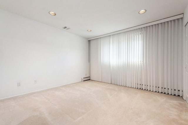 carpeted empty room featuring baseboard heating