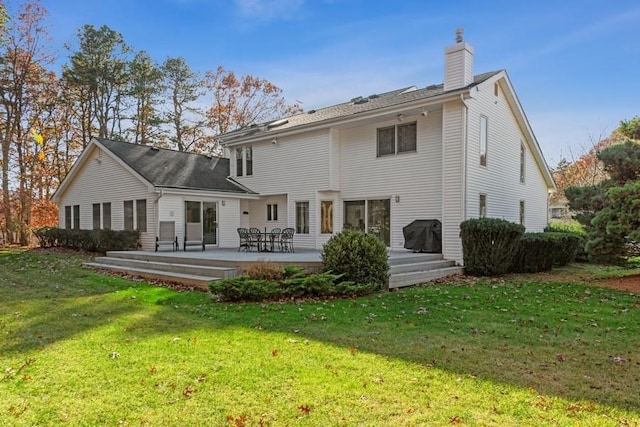 back of house featuring a lawn and a deck