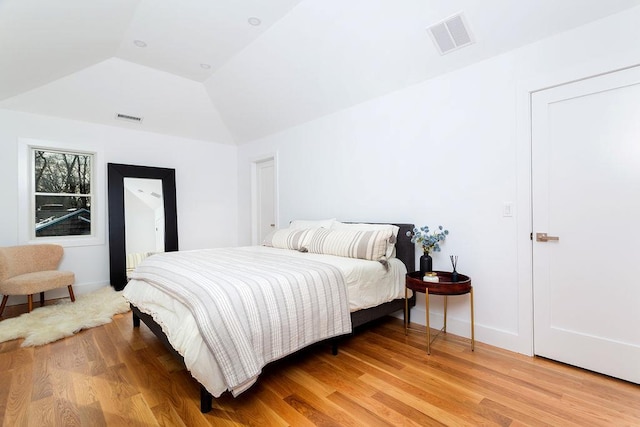 bedroom with vaulted ceiling and hardwood / wood-style floors